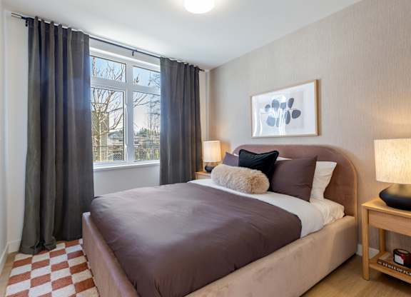 A bedroom with a large bed and a window with curtains in Hillcrest Ave located in Abbotsford, BC