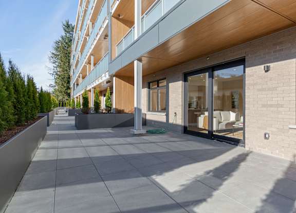 A long building with a balcony and a walkway in front in Hillcrest Ave located in Abbotsford, BC