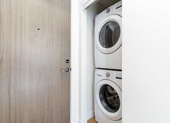 A white washing machine is in a small laundry room in Hillcrest Ave located in Abbotsford, BC