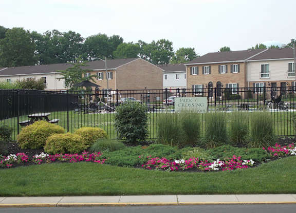 A park with a sign that says "park crossing" is in front of a building.
