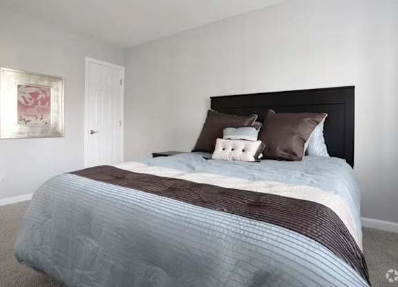 A bed with a striped comforter and two pillows is in the image.