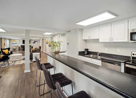 Modern kitchen with long counter and bar stools at Villages at Gateway, Denver, Colorado