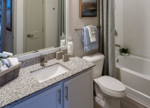 Full bathroom with granite vanity and tub at Ciel Luxury Apartments, Jacksonville