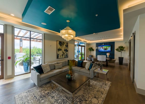 Clubhouse lounge with sectional sofa and teal ceiling at Ciel Luxury Apartments, Jacksonville