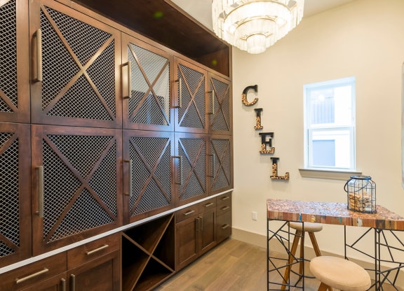 Butler pantry with mesh cabinet doors and chandelier at Ciel Luxury Apartments, Jacksonville, Florida