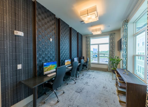 Business center with workstations and patterned accent wall at Ciel Luxury Apartments, Jacksonville, FL