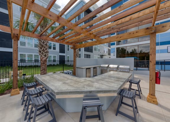 Outdoor kitchen with grills under wooden pergola at Ciel Luxury Apartments, Jacksonville, FL 32246