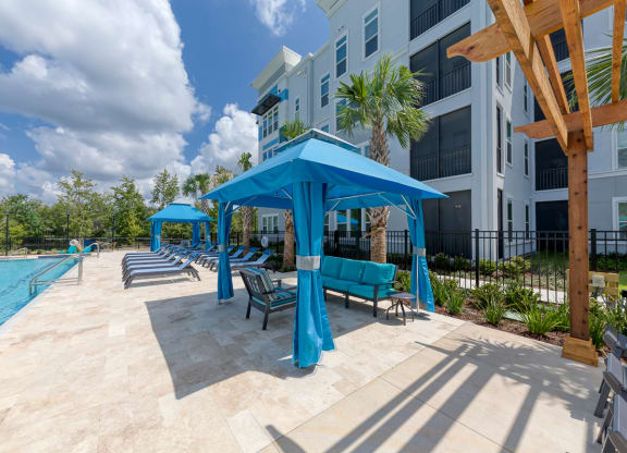 Poolside cabana with teal fabric and lounge seating at Ciel Luxury Apartments, Jacksonville, 32246