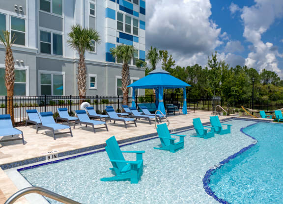 Swimming pool with in water chairs and blue gazebo at Ciel Luxury Apartments, Jacksonville, 32246