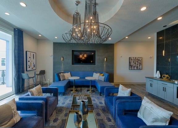 Modern clubhouse with blue furniture and tv at Ciel Luxury Apartments, Jacksonville, FL 32246