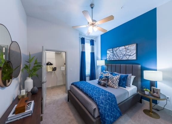 Modern bedroom with blue accent wall at Ciel Luxury Apartments, Florida