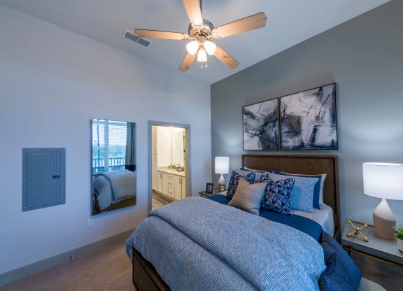 Bedroom with blue linens and artwork at Ciel Luxury Apartments, Jacksonville, FL