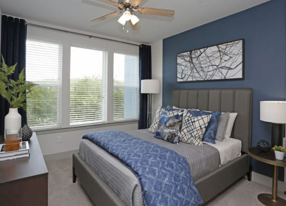 Bedroom with gray upholstered headboard and blue decor at Ciel Luxury Apartments, Jacksonville, FL