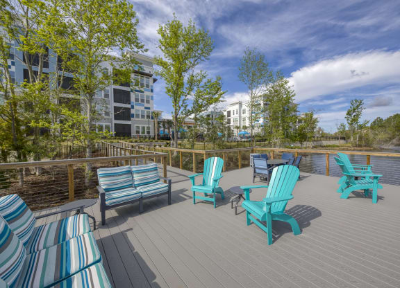 Waterfront deck with colorful seating and lake view at Ciel Luxury Apartments, Jacksonville, FL