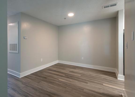 A room with wooden flooring and white walls.