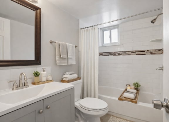 A white bathroom with a toilet, sink, and bathtub.