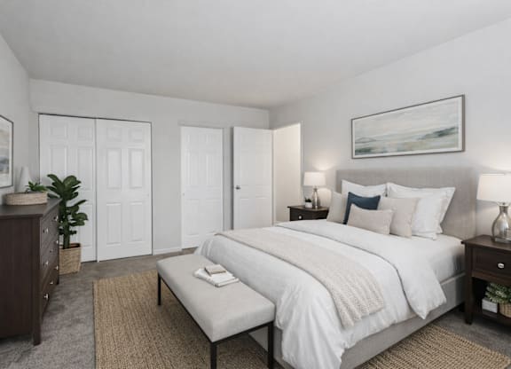 A bedroom with a large bed, a dresser, and a nightstand.