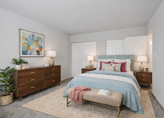 A bedroom with a bed, nightstands, and a rug.