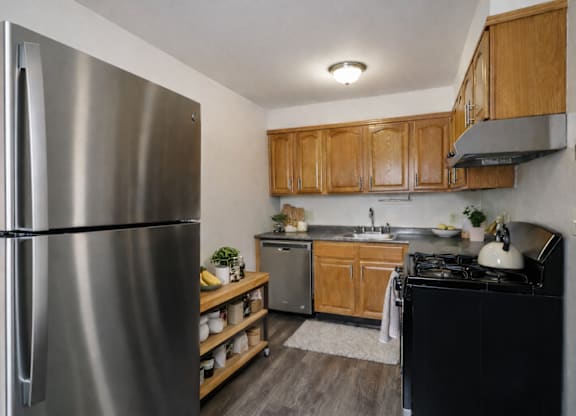 A modern kitchen with a stainless steel refrigerator and wooden cabinets.