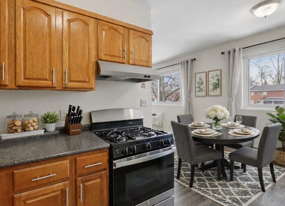 A kitchen with wooden cabinets and a black stove top oven.