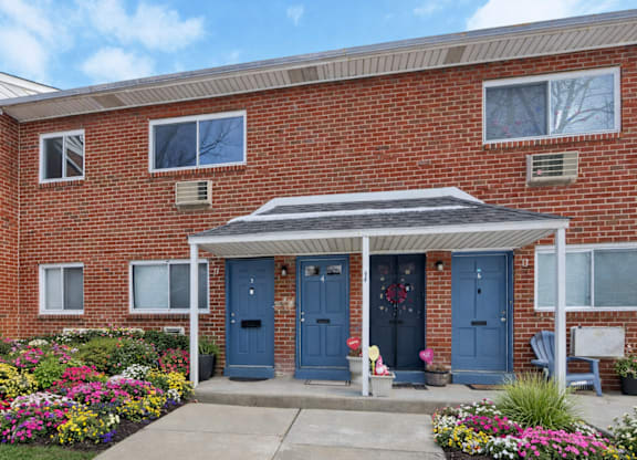 A red brick house with a blue door and a small porch.