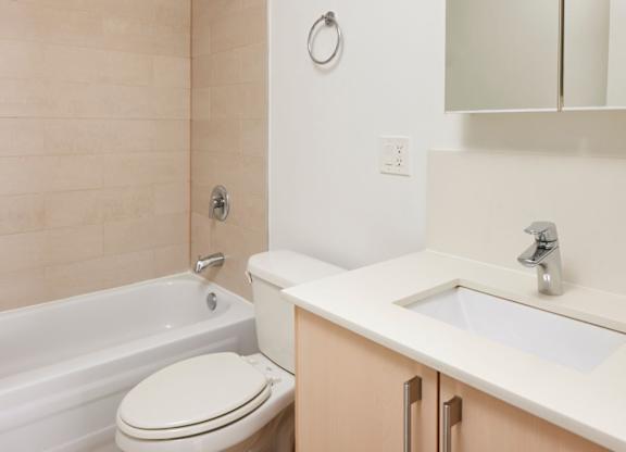 A white toilet sits next to a bathtub in a bathroom.