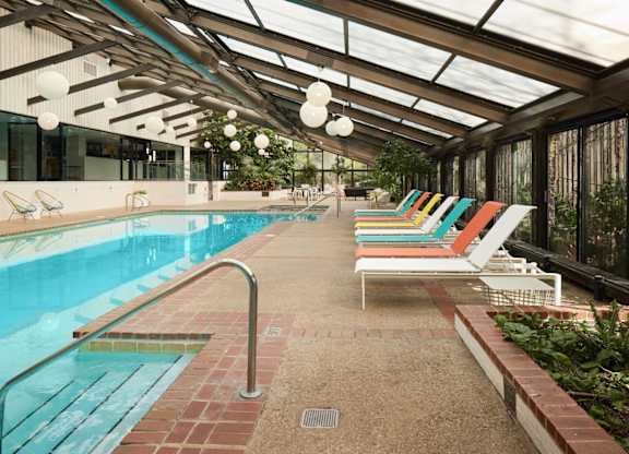 A pool with a metal railing and a glass ceiling.