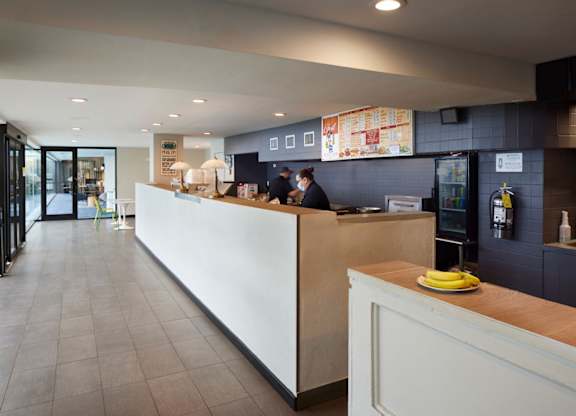 A white reception desk with a yellow plate on top.