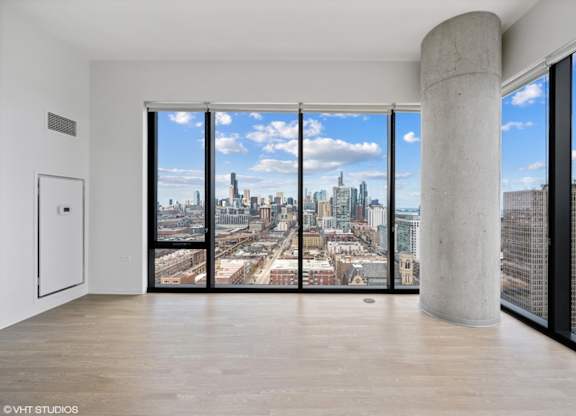 A large room with a view of the cityscape outside the window.