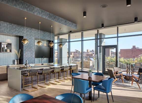 A modern kitchen and dining area with blue chairs and a wooden table.