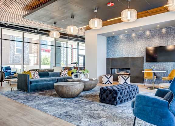 A modern living room with a fireplace and a blue chair.