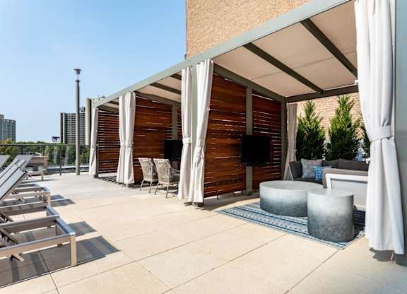 A patio with a white umbrella and a white chair.