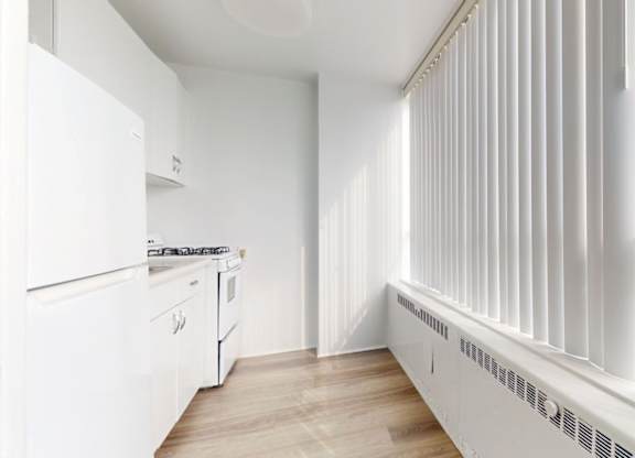 A white kitchen with a stove, oven, and cabinets.