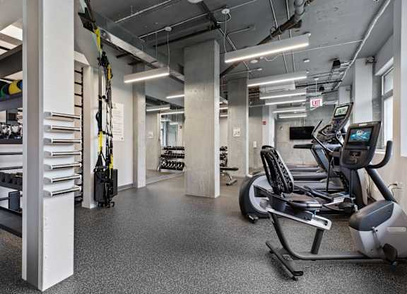 A gym with treadmills, exercise bikes, and other equipment.
