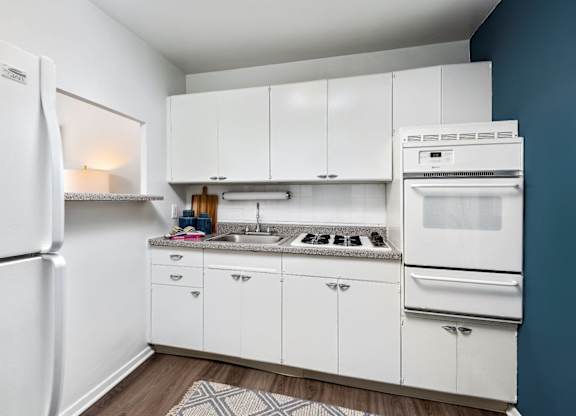 A kitchen with white cabinets and appliances.