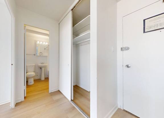 A white bathroom with a toilet, sink, and mirror.