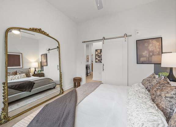 A bedroom with a large bed and a large mirror.at Adler Montford Park + Drexel Townes, Charlotte, NC, 28209