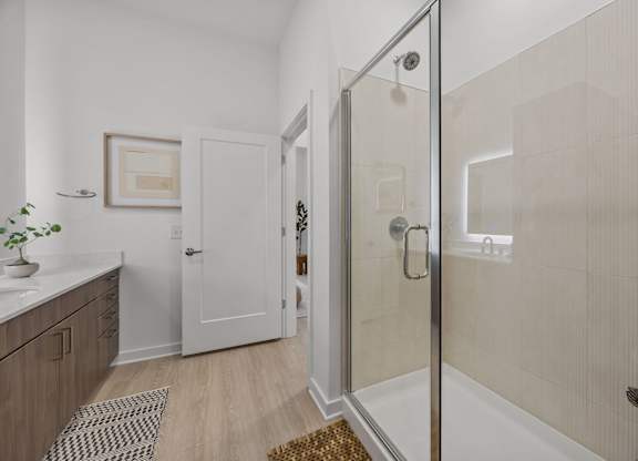 A bathroom with a walk-in shower and a plant on the counter.at Adler Montford Park + Drexel Townes, Charlotte, NC, 28209