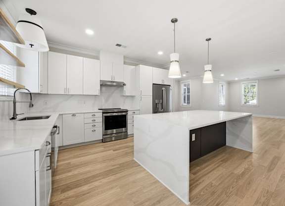A modern kitchen with white cabinets and a large island.