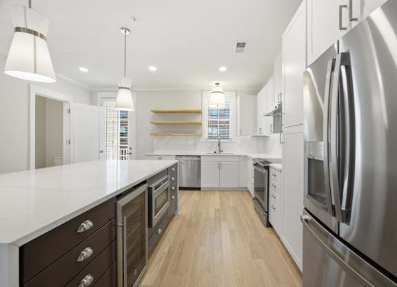 A modern kitchen with stainless steel appliances and wooden floors.