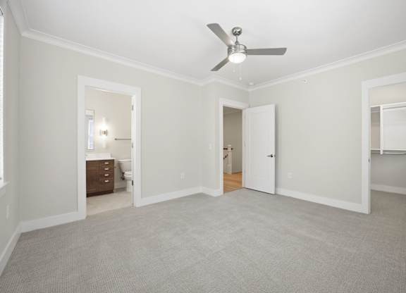 A room with a ceiling fan and carpeted floor.