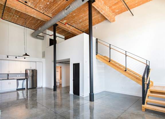 A room with a wooden ceiling and a staircase. at Judson Mill Lofts and The Jenny & Westervelt in Greenville, SC