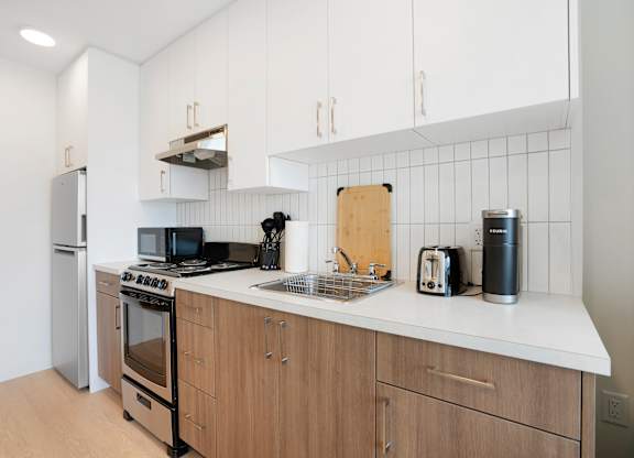 A modern kitchen with wooden cabinets and a white countertop.
