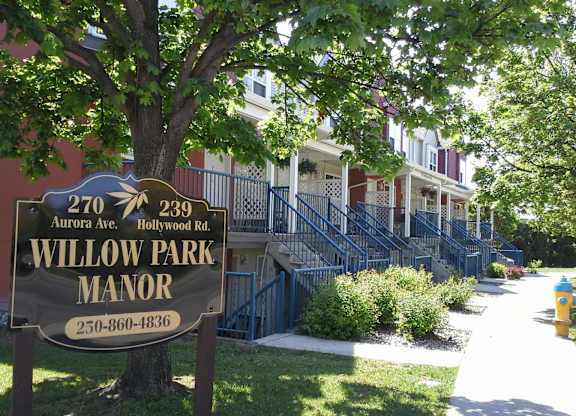 A brown sign with Willow Park Manor written on it.