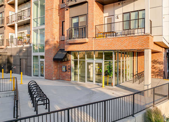 A modern building with a red brick facade and black metal railings.