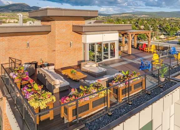 A patio with a table and chairs overlooking a mountainous landscape.