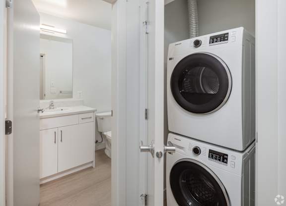A white washing machine is in a small room.