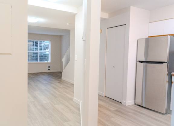 A kitchen with a refrigerator and a stove top oven.