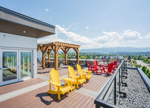 A patio with yellow chairs and a red chair.