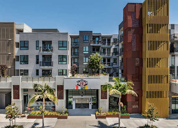 Modern apartment building entrance with landscaping at AMP 30 Apartments, San Diego